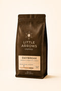 Coffee bag from Little Arrows Coffee with 'Daybreak' flavor on a beige background